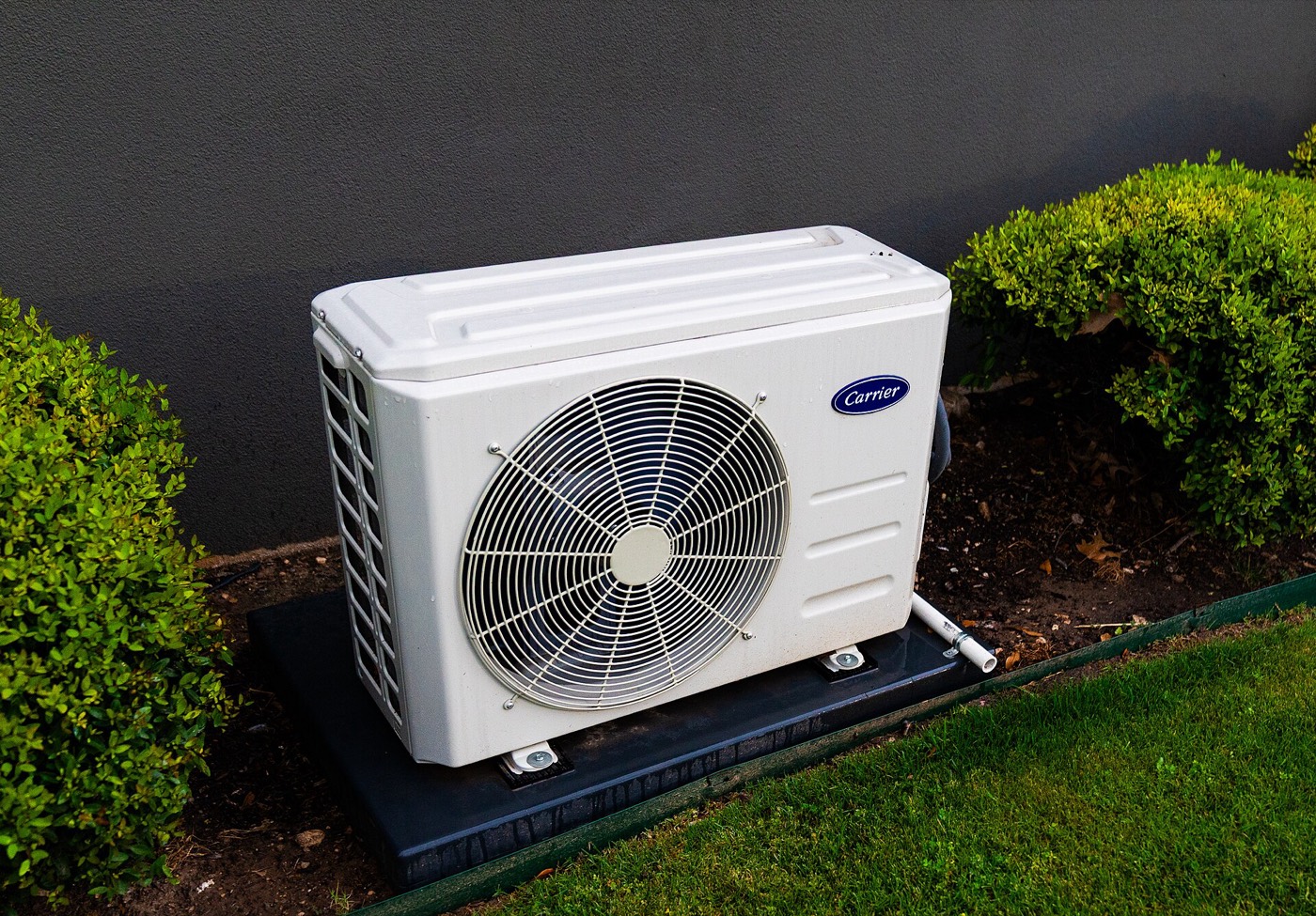 Heat pump outdoor unit installed on a level pad beside a Metro Vancouver home